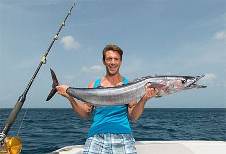 Pêcheur ayant capturé un gros barracuda à la traîne aux îles Canaries