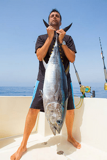 un pêcheur avec un gros thon sur un bateau