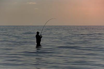 Pêcheur au coucher du soleil sur la plage des îles Baléares