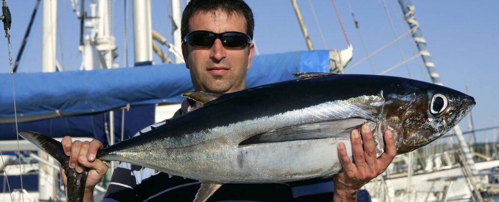 Pêcheur récréatif tenant un thon capturé dans les eaux atlantiques