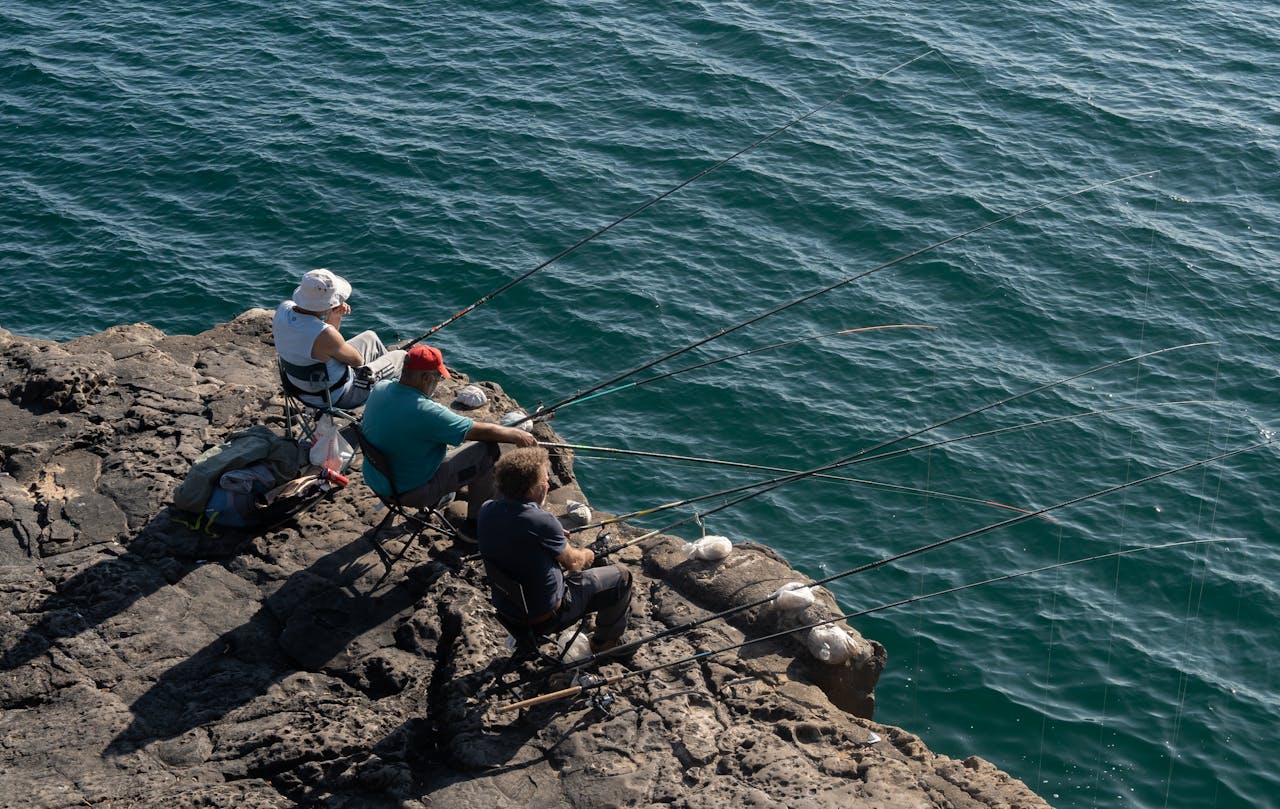 Pêcheurs récréatif sur les rochers de lave noire d'une île des Canaries face à l'Atlantique